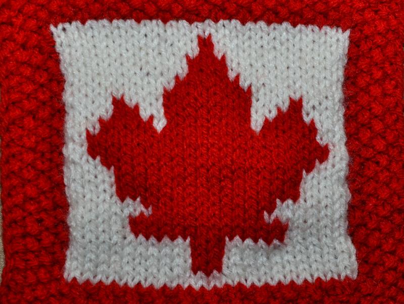 Finished knitted maple leaf pattern in red on white — example of a completed Canada Day dishcloth